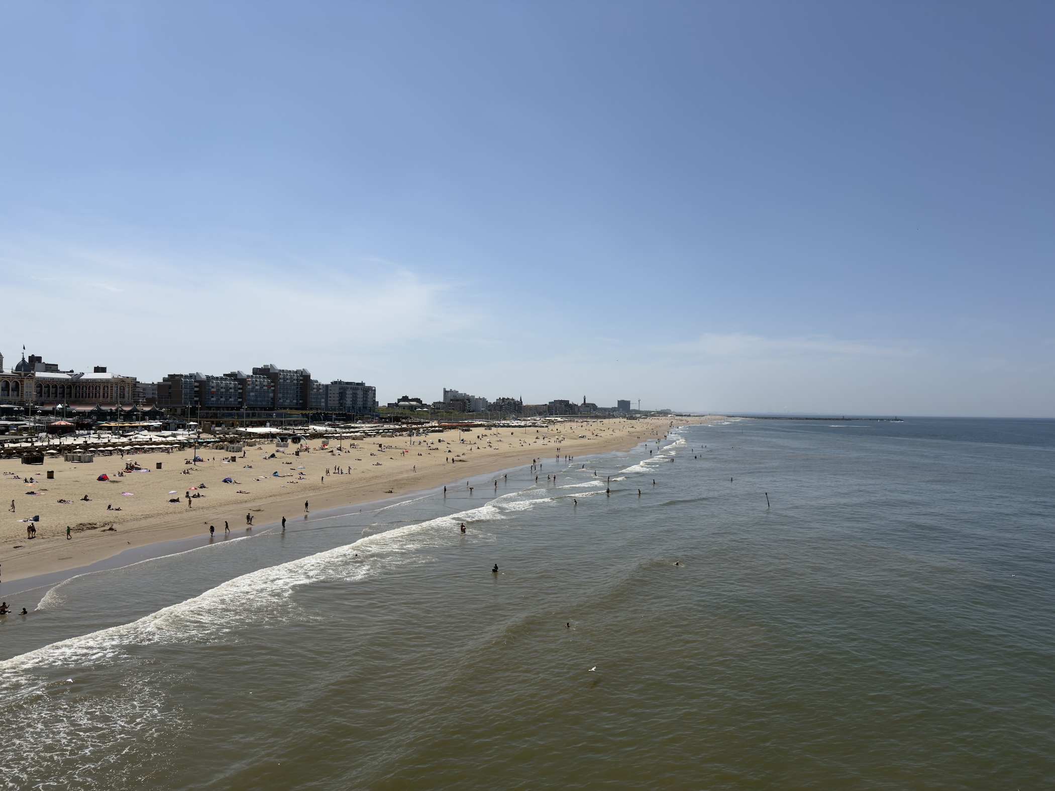 Long sandy beach and gentle surf stretching towards the town of Scheveningen in the distance.