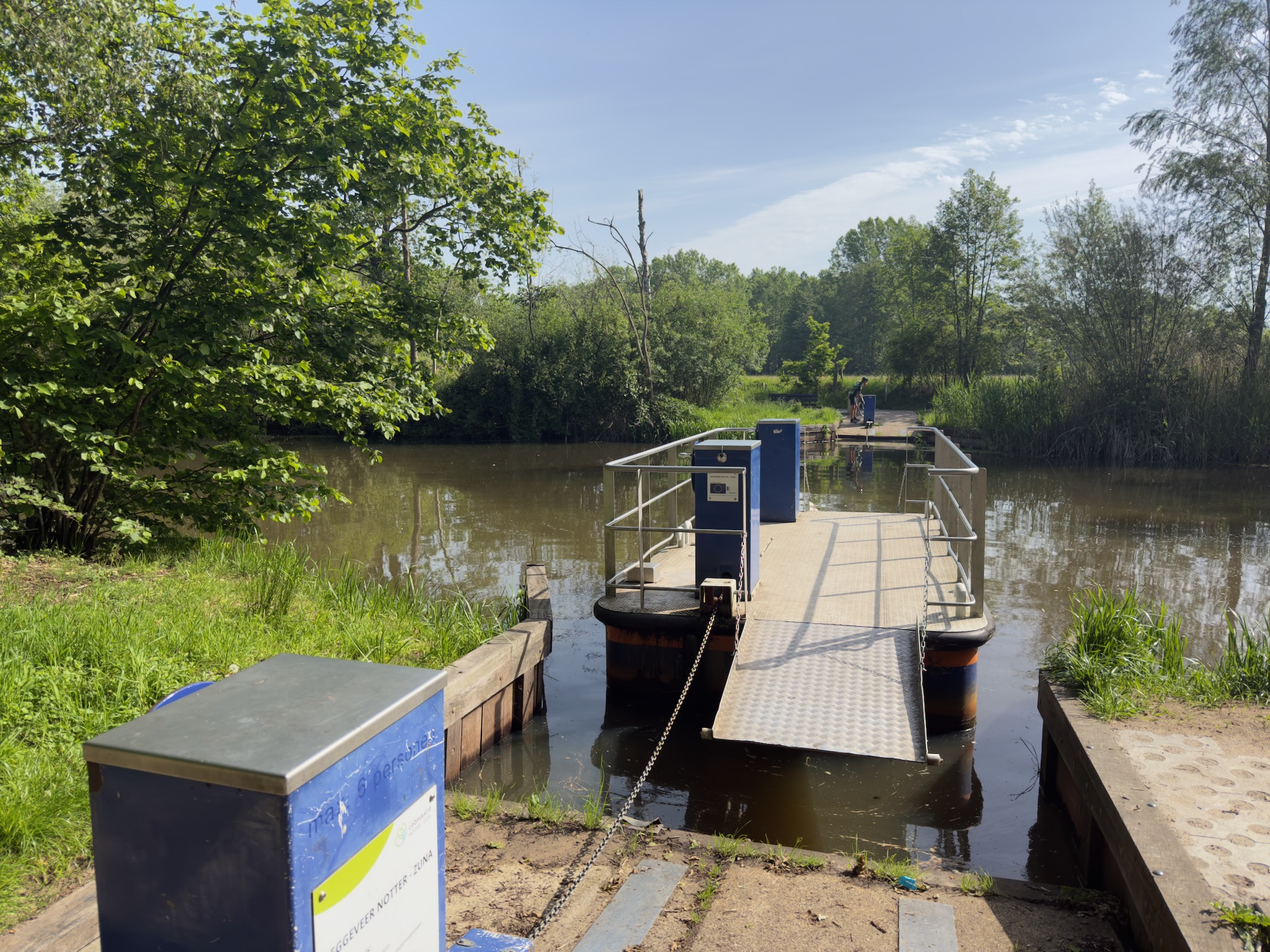 Cable ferry moored at the riverbank with a chain anchoring it to the shore