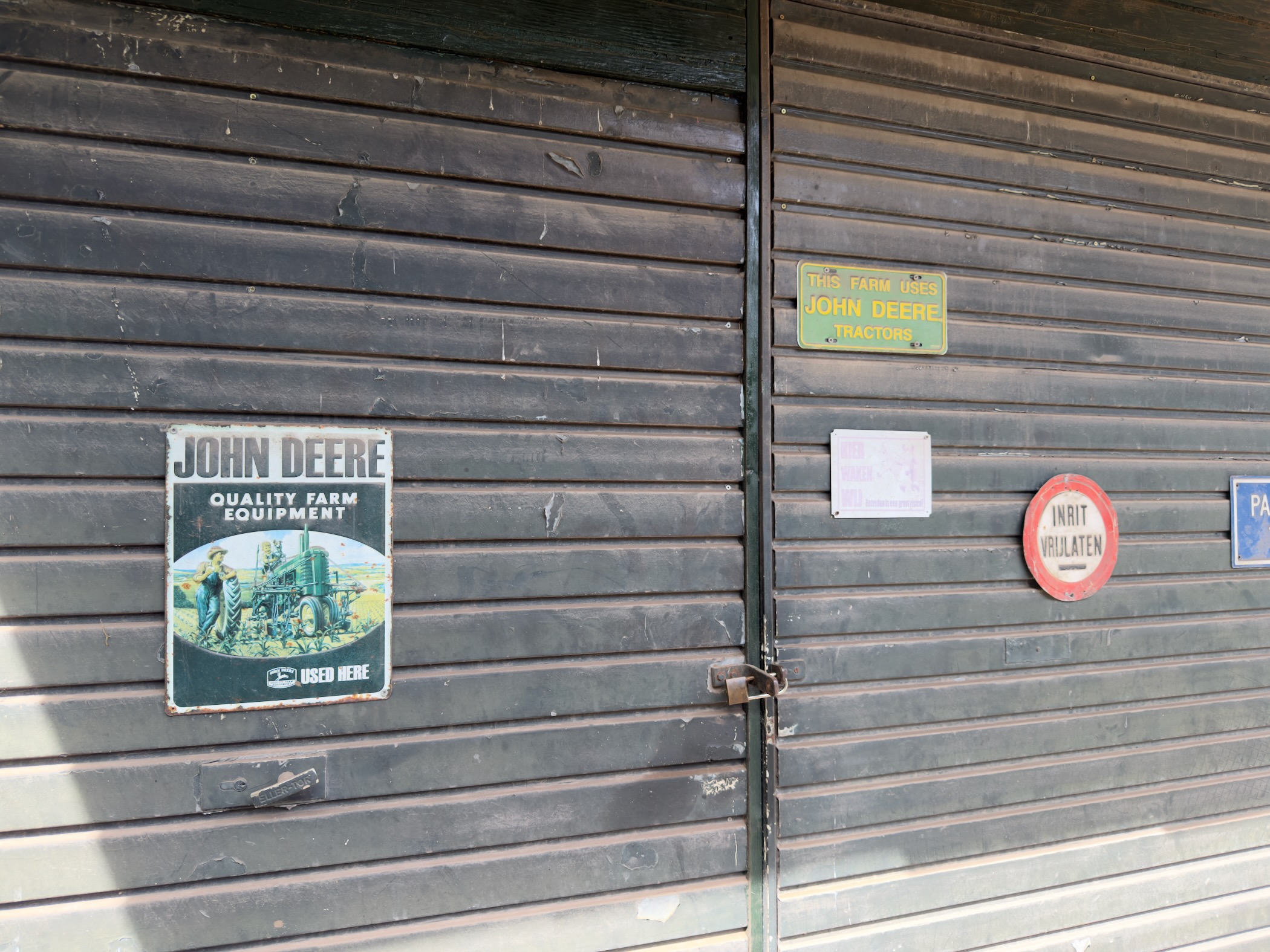 Weathered wooden barn doors decorated with vintage John Deere advertising signs