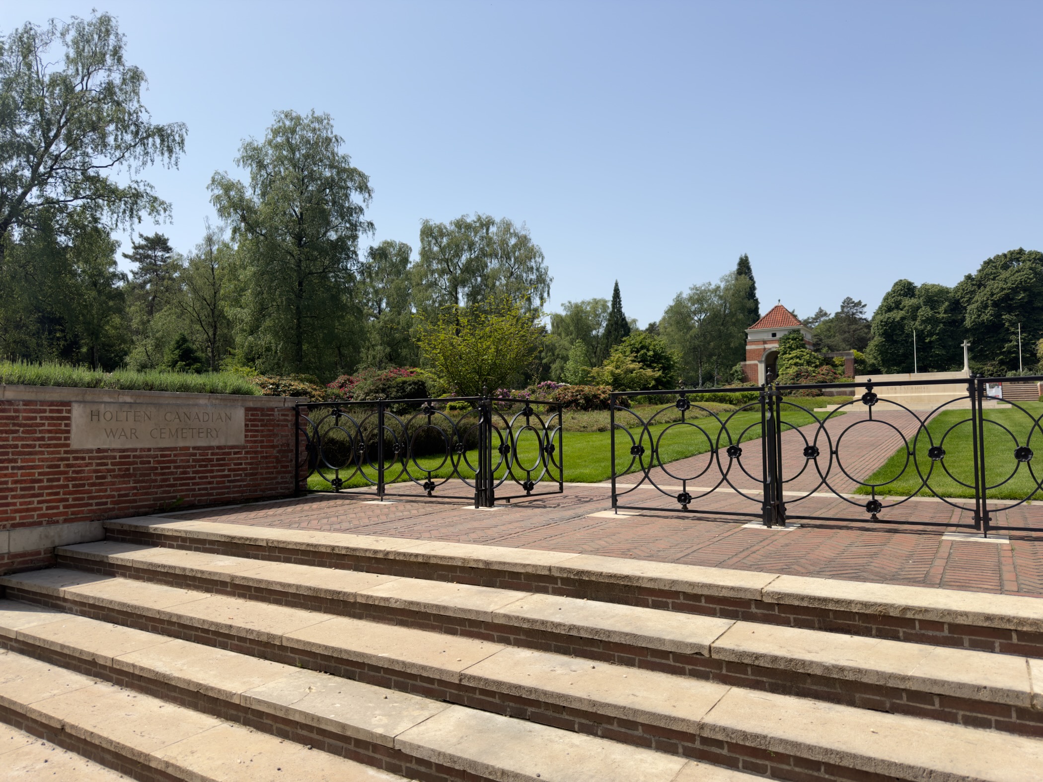 Wrought iron gate and brick steps at the entrance of the Canadian War Cemetery at Holten