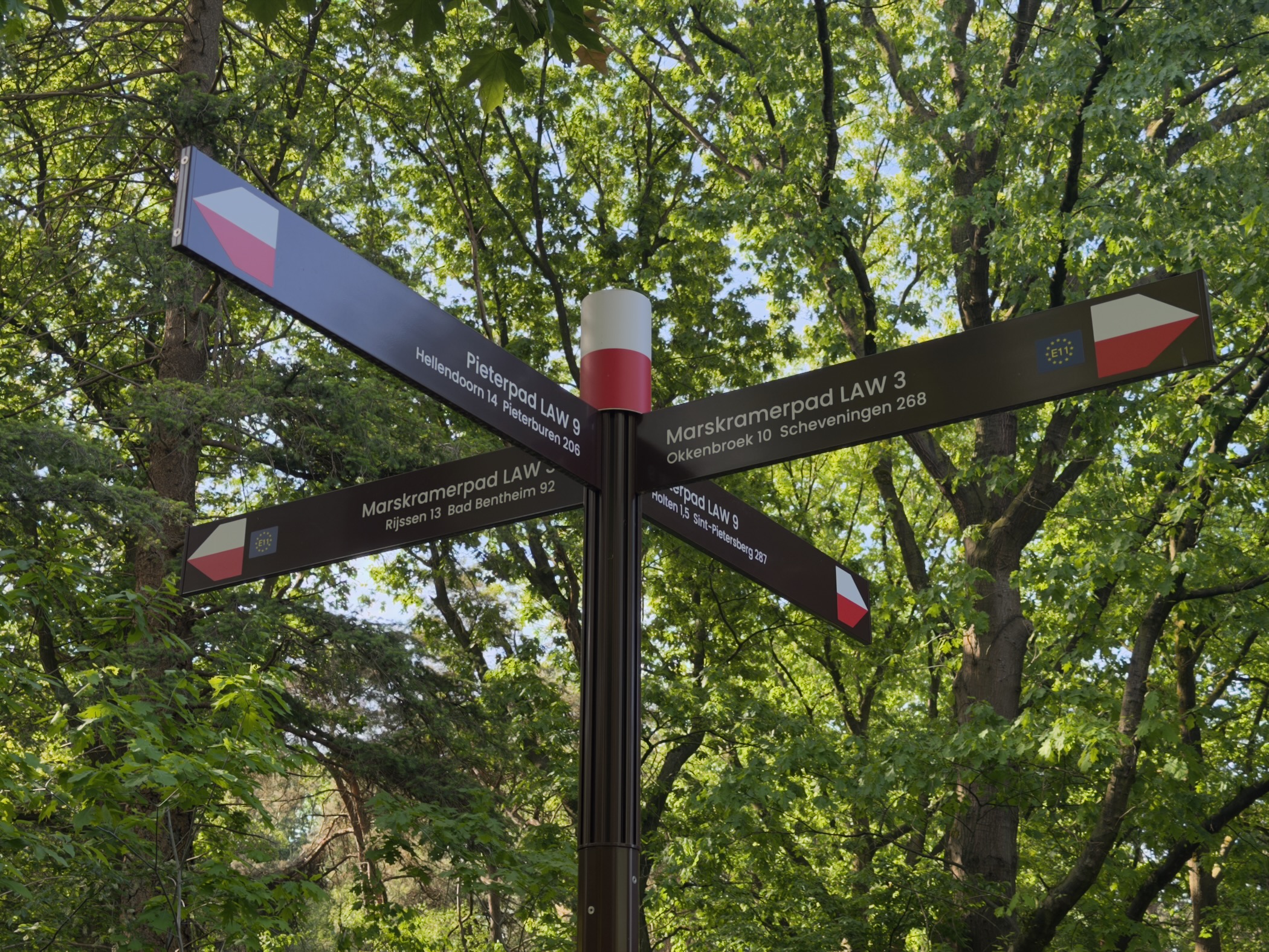 Long-distance footpath signpost on the Holterberg pointing to Marskramerpad and Pieterpad routes