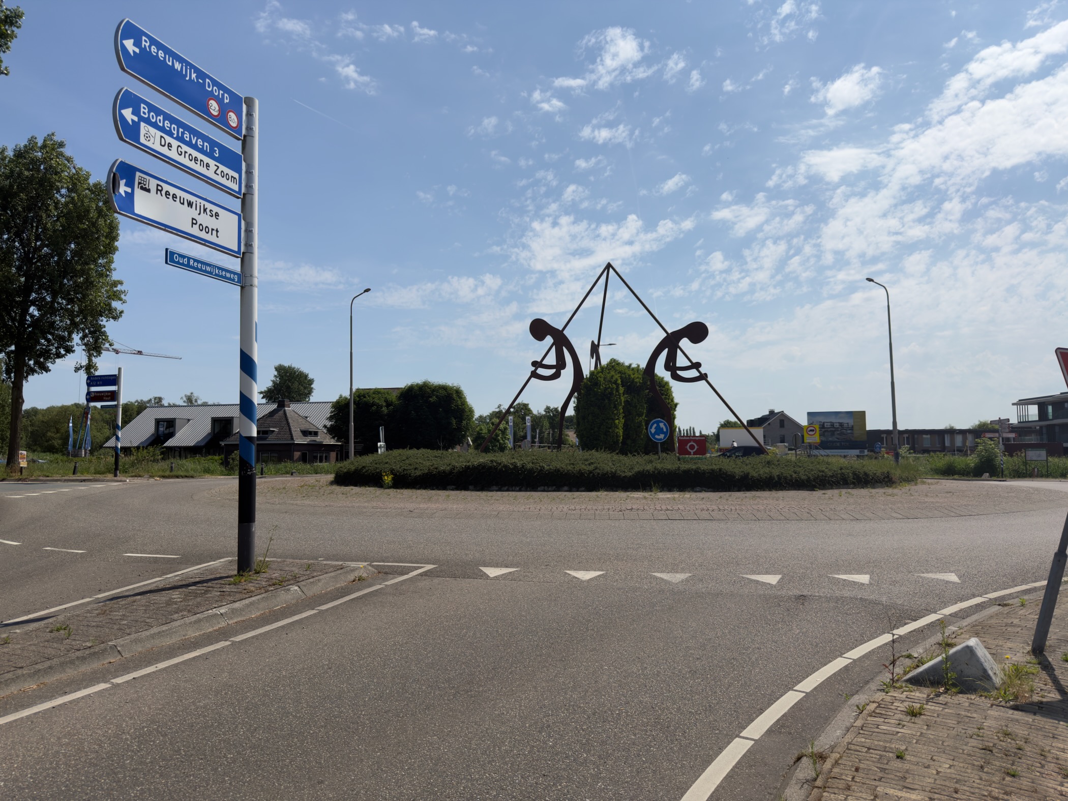 Roundabout on the edge of Reeuwijk with an abstract metal sculpture at its centre and direction signs in the foreground