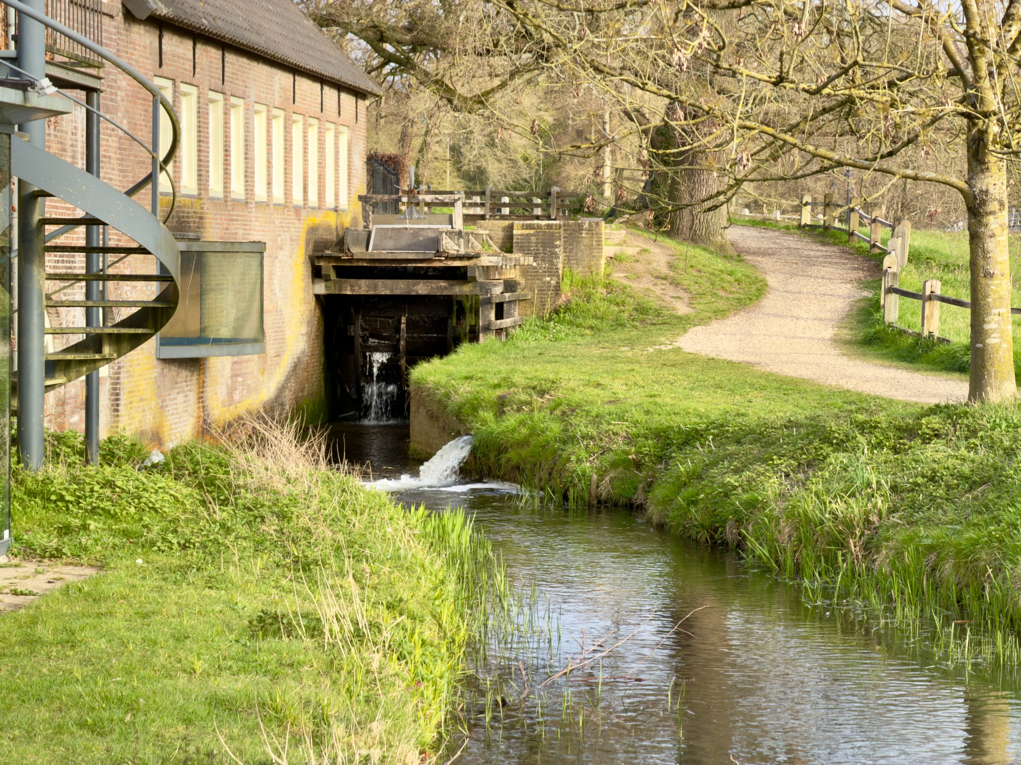 Watermill sluice with a stream flowing through a green park