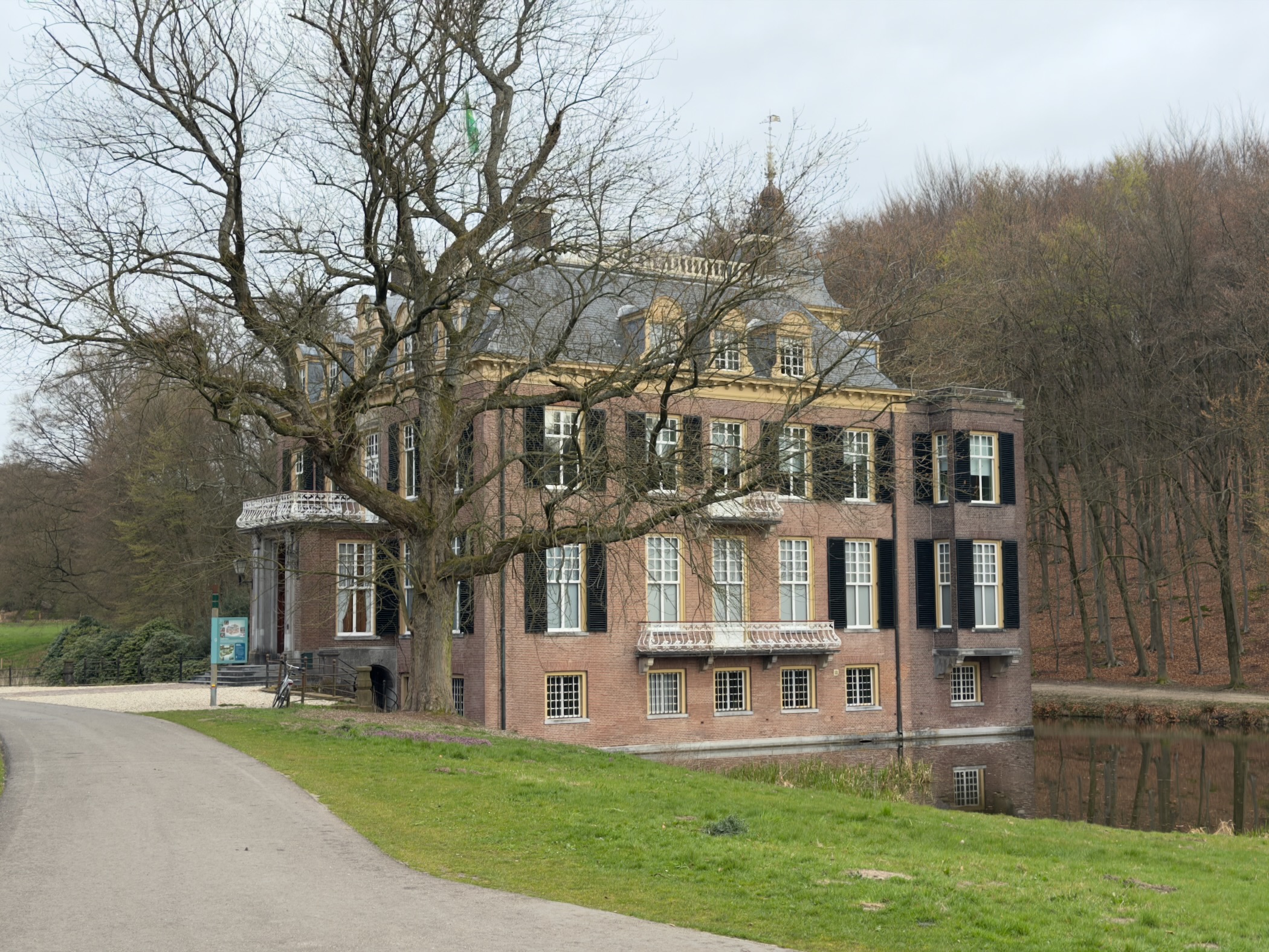 Historic manor house with a moat surrounded by bare trees