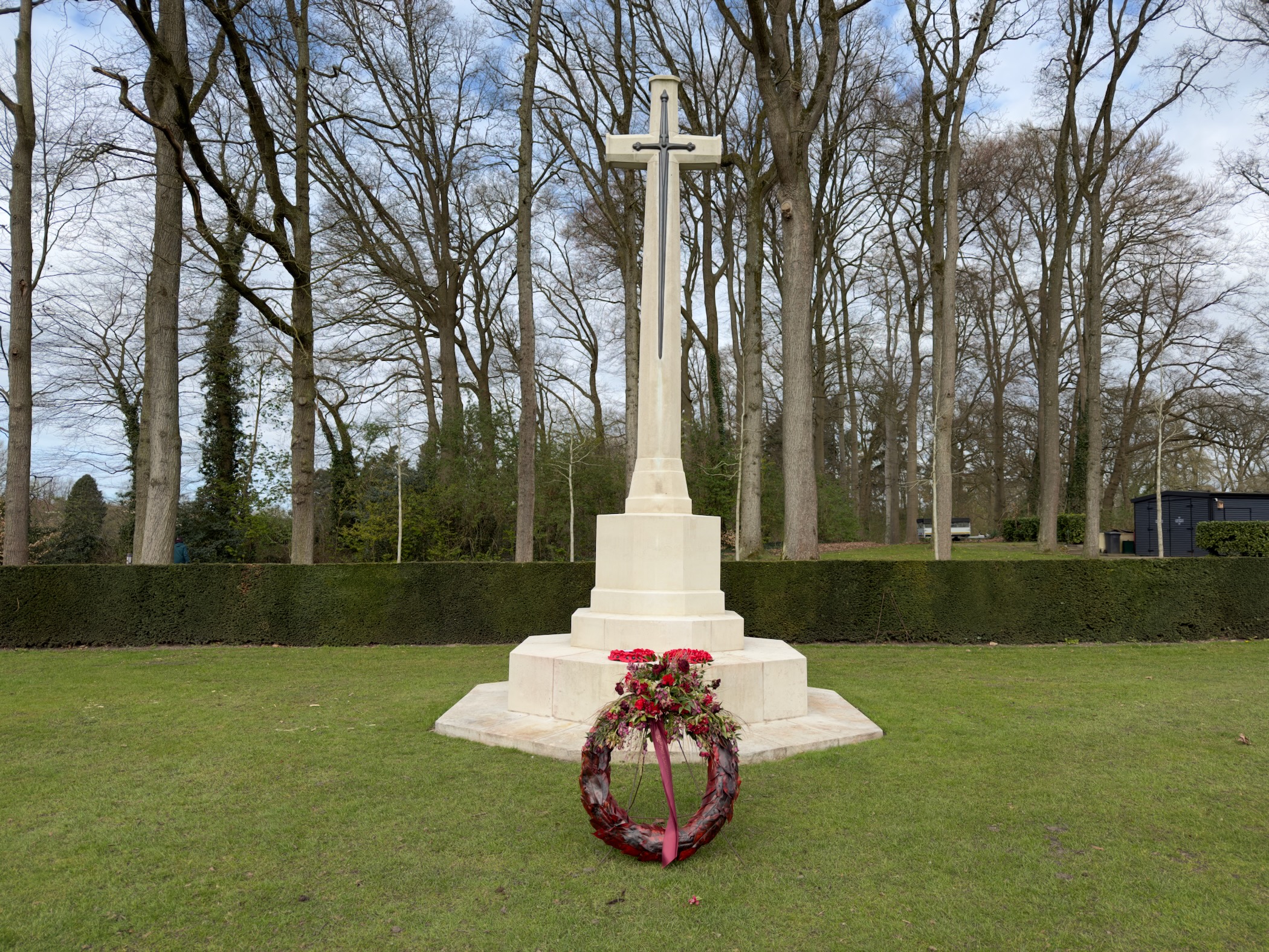 War memorial cross with a poppy wreath at Oosterbeek War Cemetery