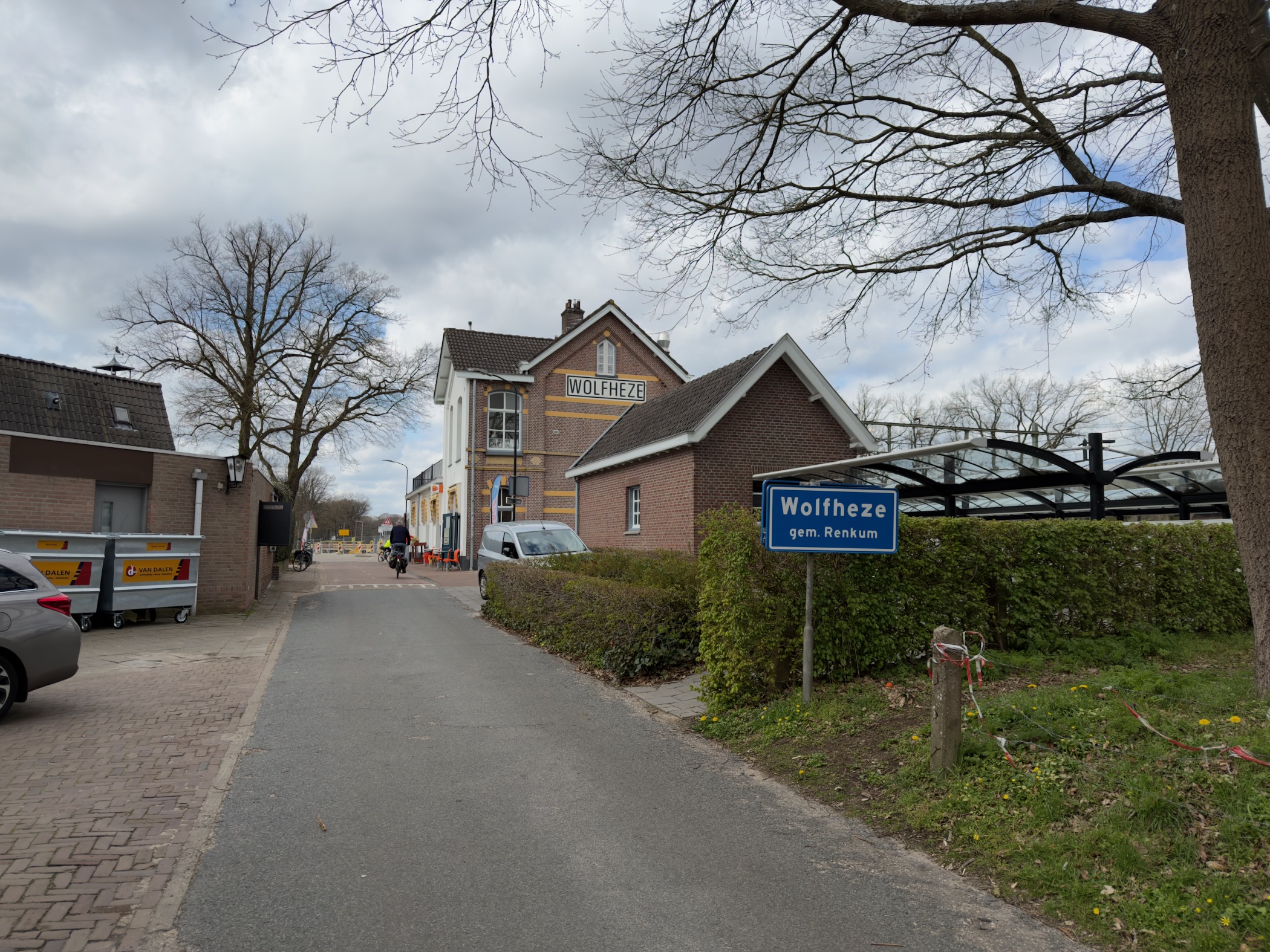 Village sign of Wolfheze with a building in the background