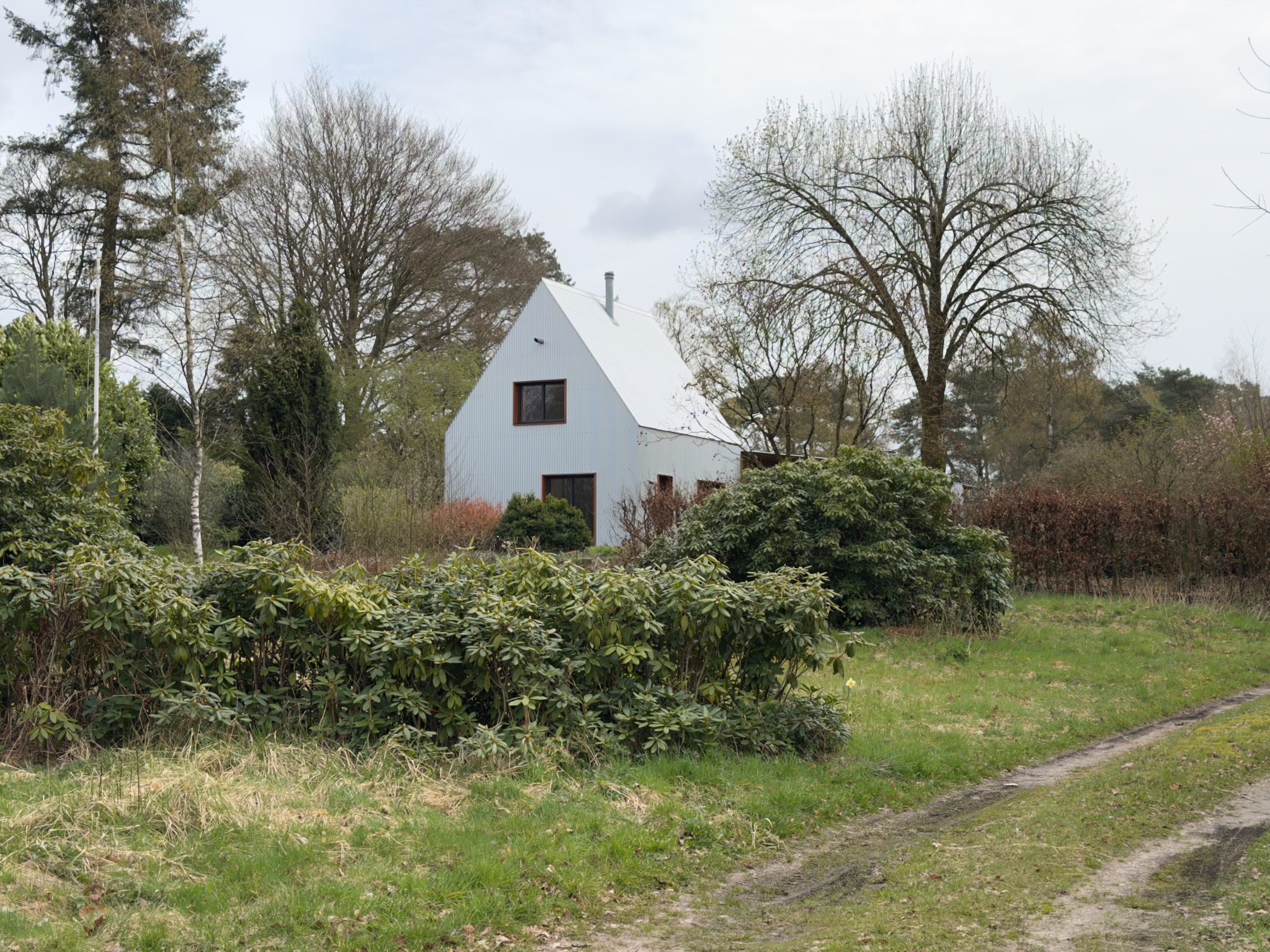 White house with a garden along a quiet rural path