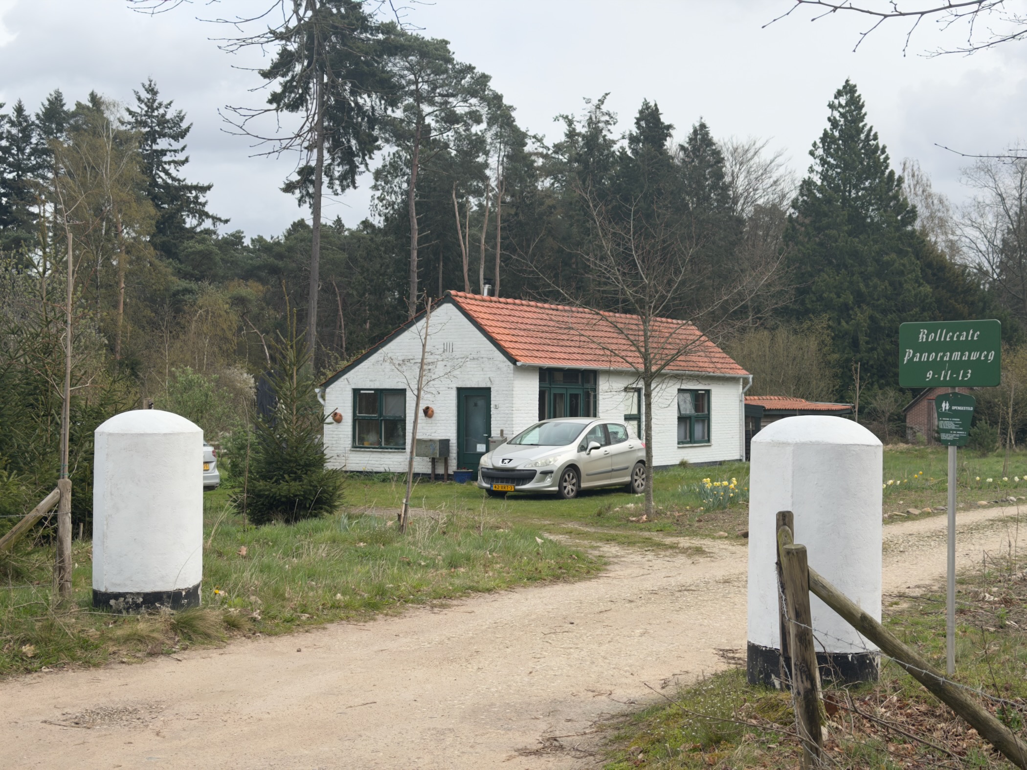 Small white house with entrance posts at a horse riding school in the forest