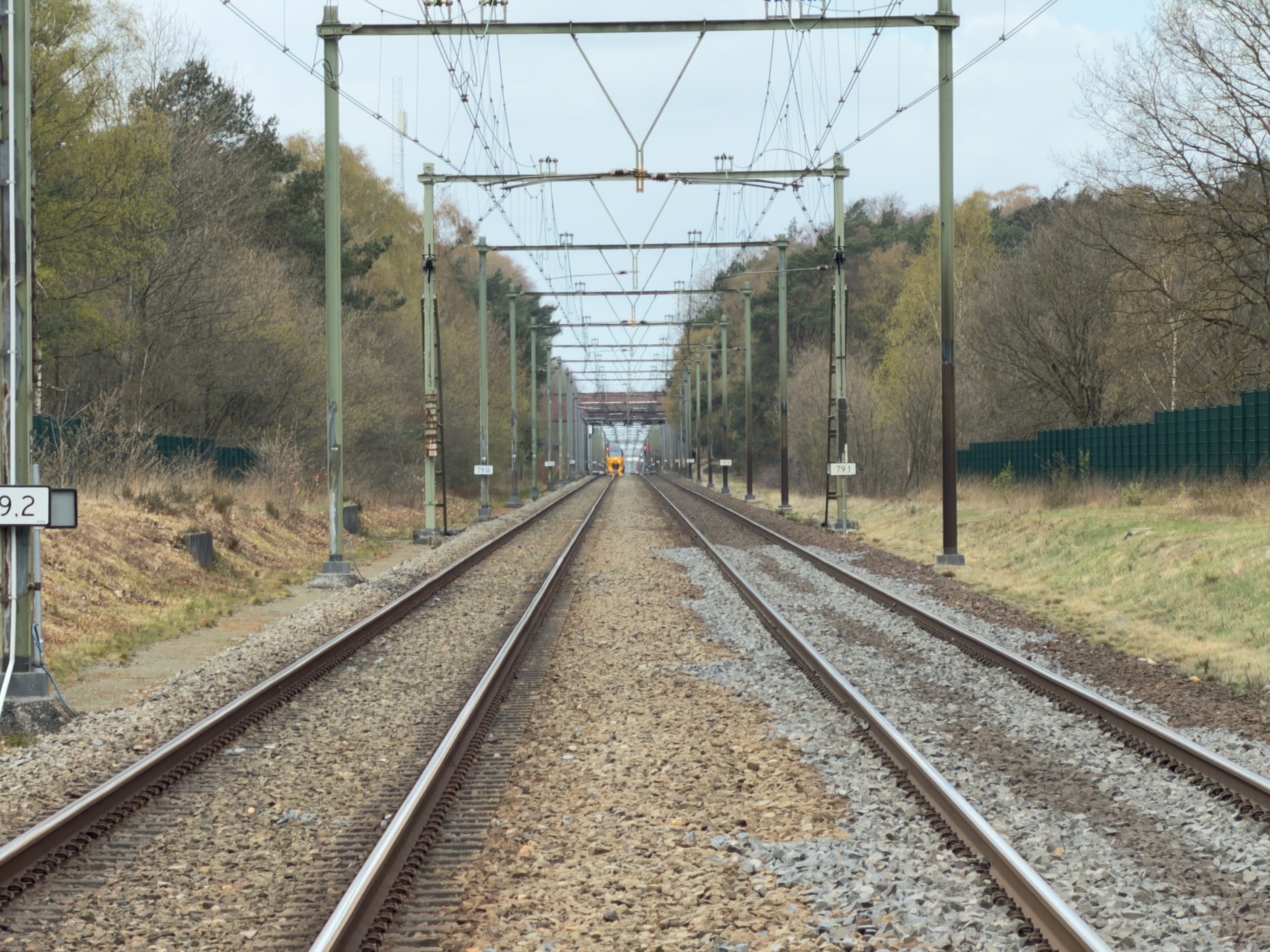 Railway tracks stretching into the distance with overhead power lines
