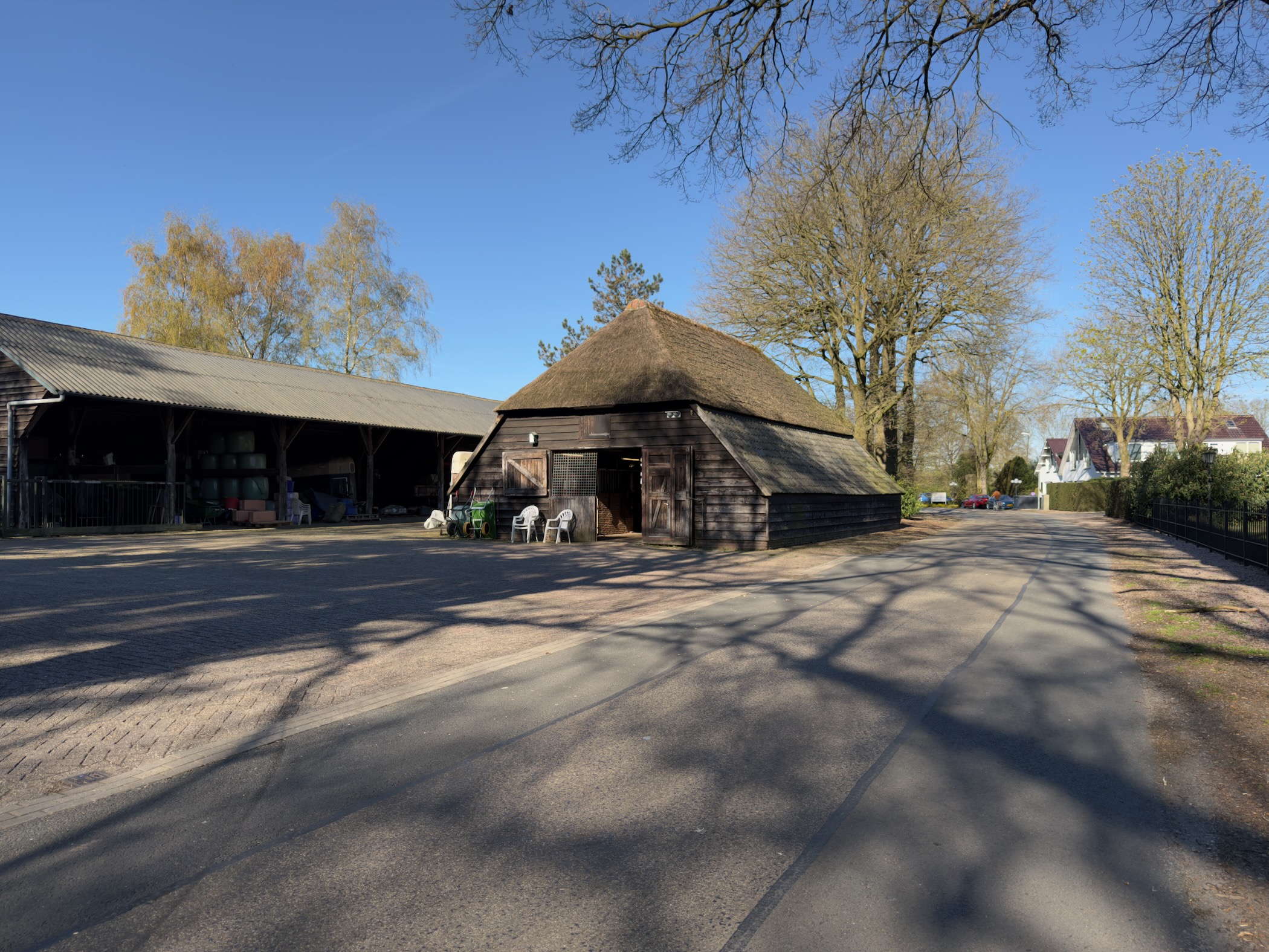 Traditional thatched barn and open shed on a farmyard near Otterlo