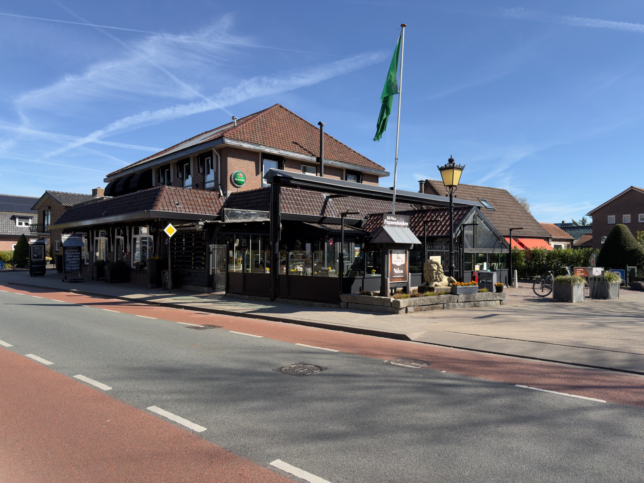 Restaurant and cafe building along the main road with a green flag
