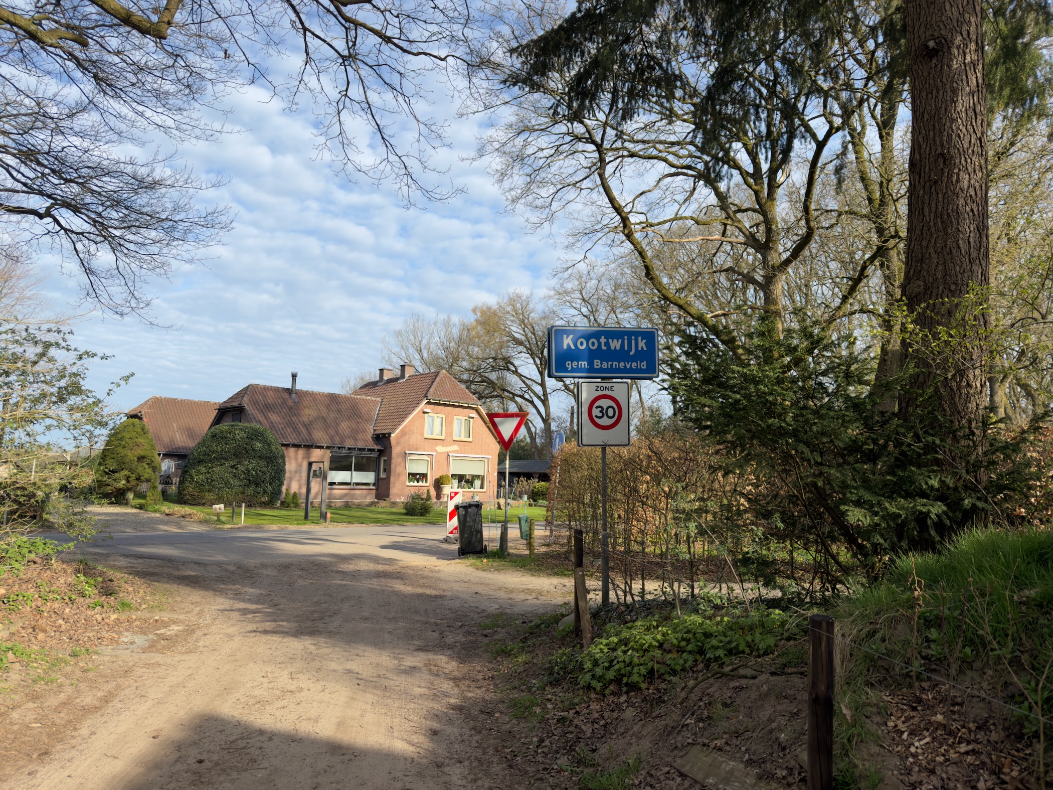 Kootwijk village sign with a thatched farmhouse and yield sign