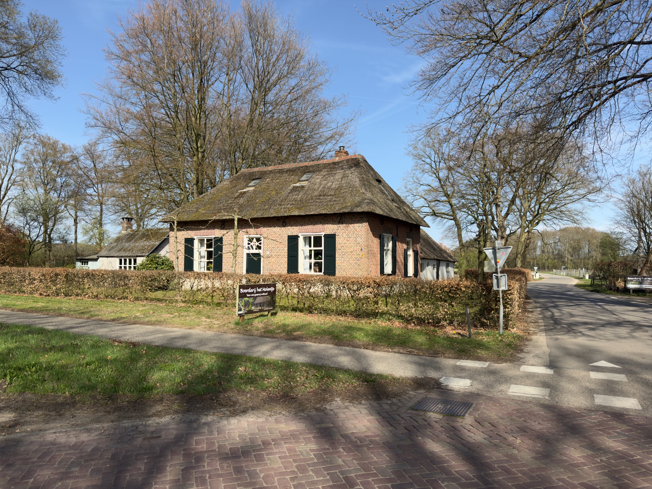 Traditional thatched-roof farmhouse at a village crossroads