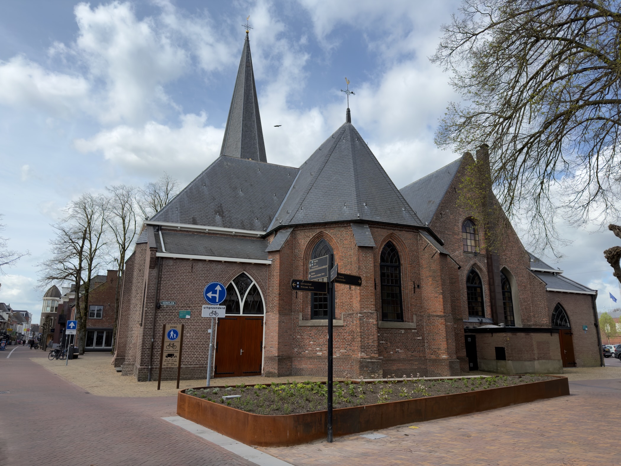Medieval brick church with a pointed spire in the centre of Putten