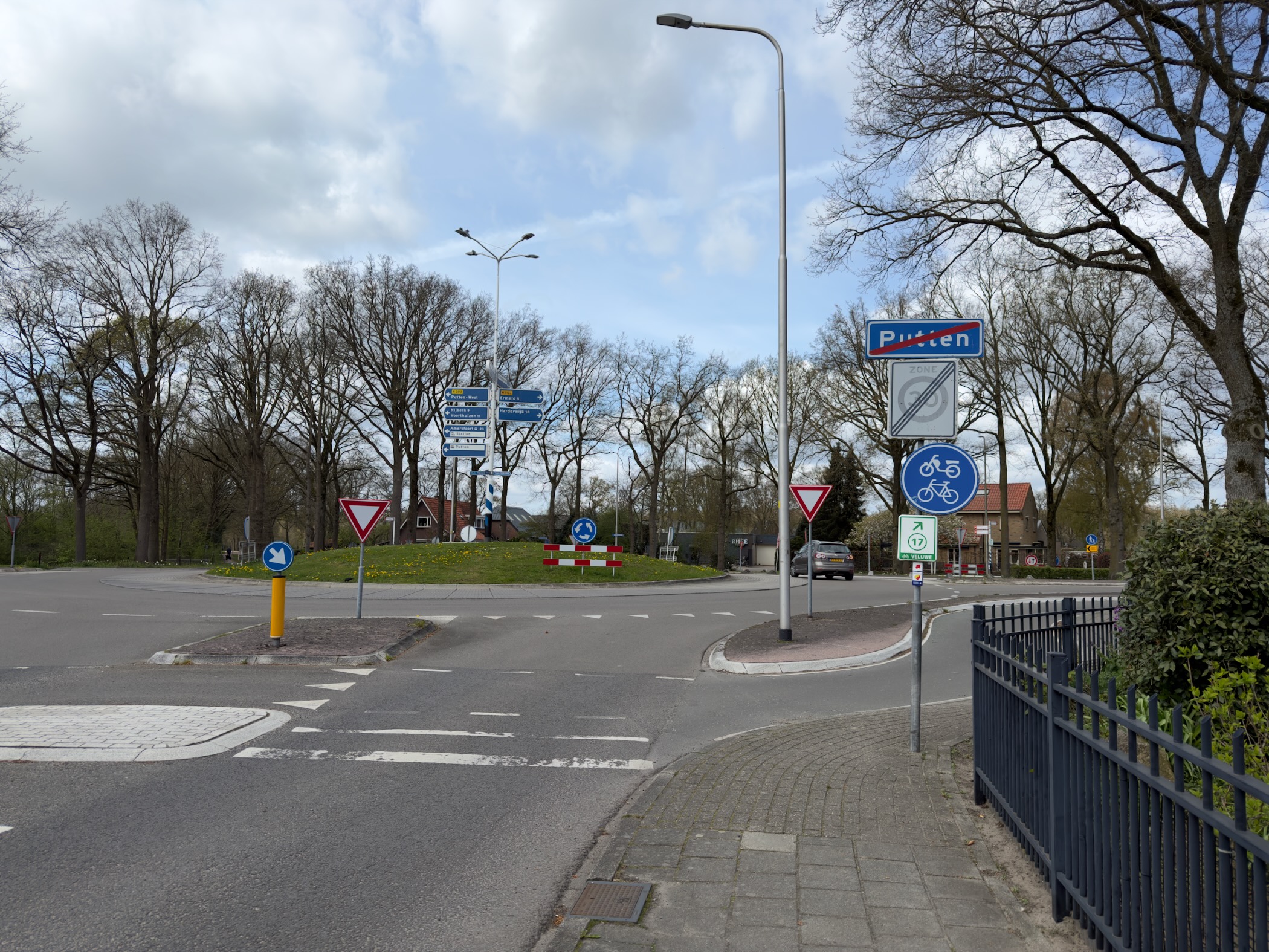 Roundabout with road signs at the edge of Putten under a cloudy sky