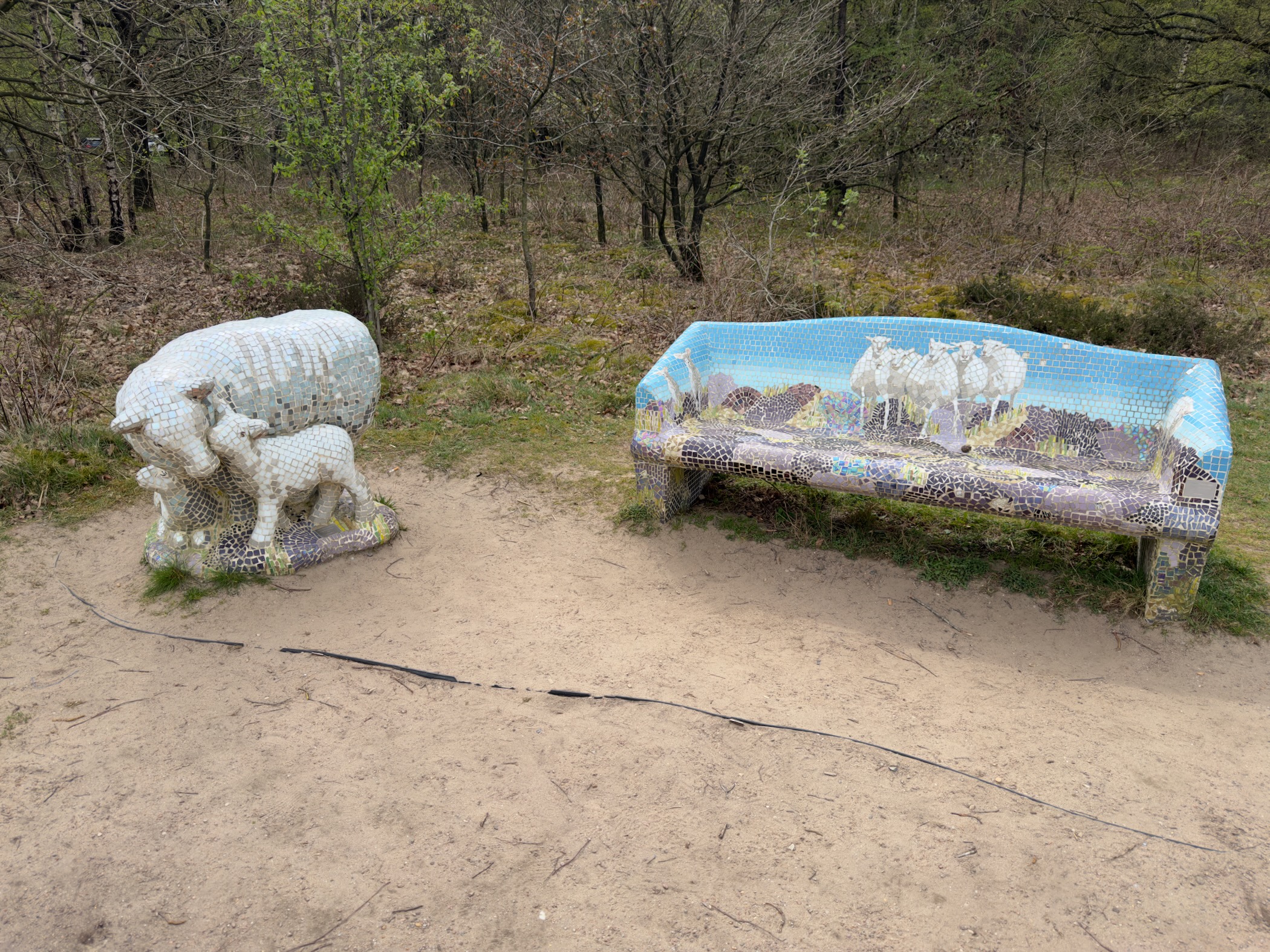 Mosaic sheep sculpture and bench with a sheep flock scene on heathland