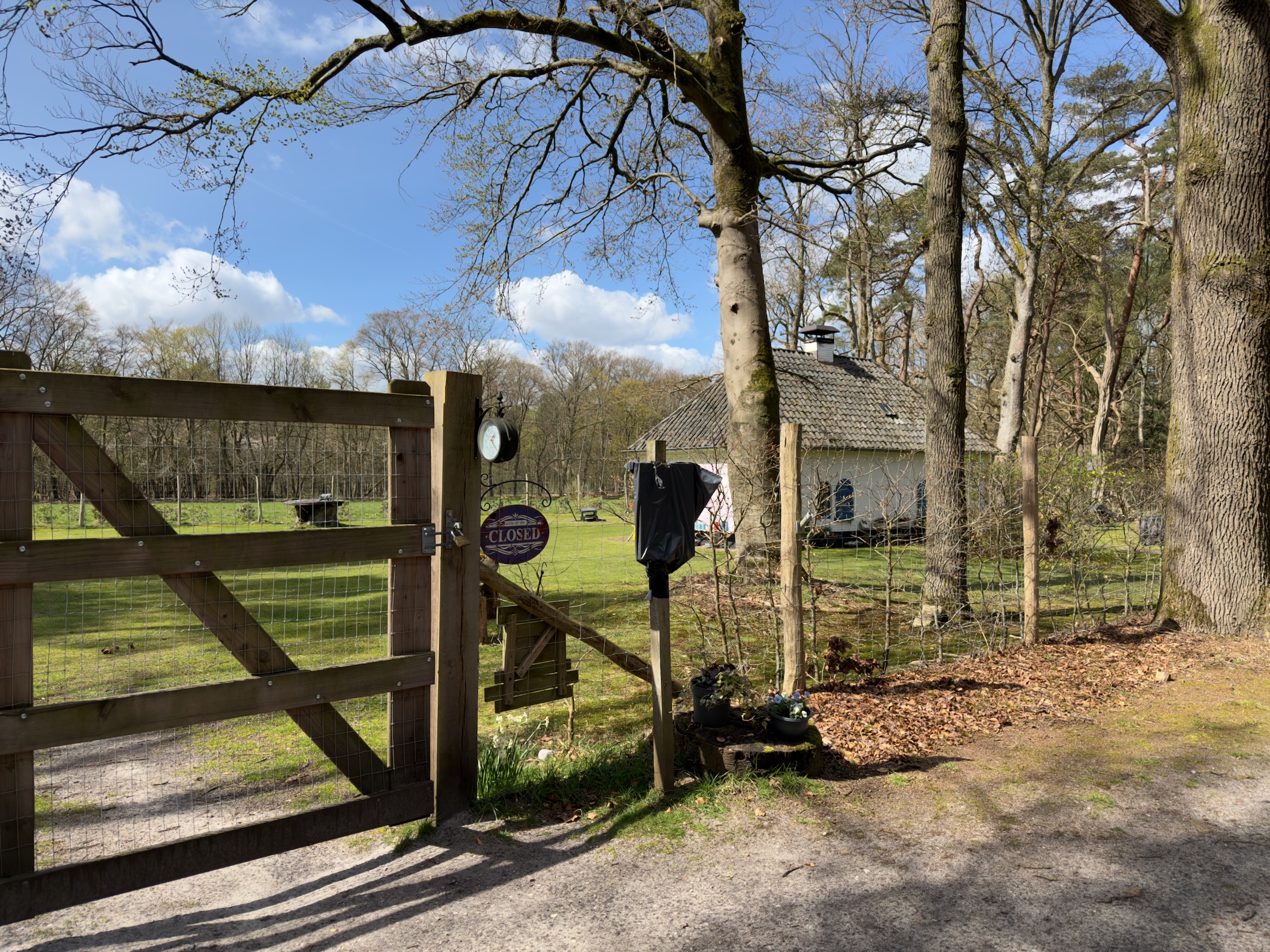 Wooden gate with a closed sign at the entrance to a rural property