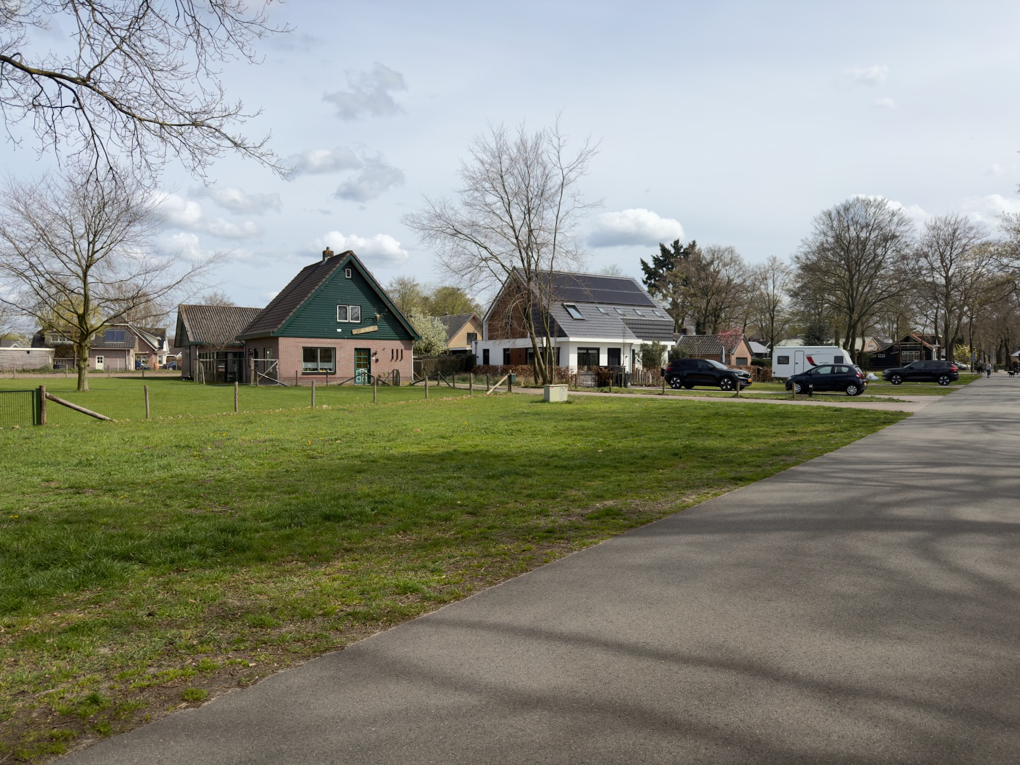 Green-gabled farmhouse and neighbouring houses on a village green in Elspeet