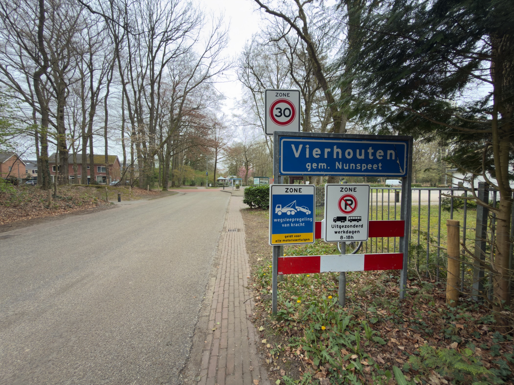 Village entrance sign of Vierhouten with a 30 km/h zone sign along a brick road