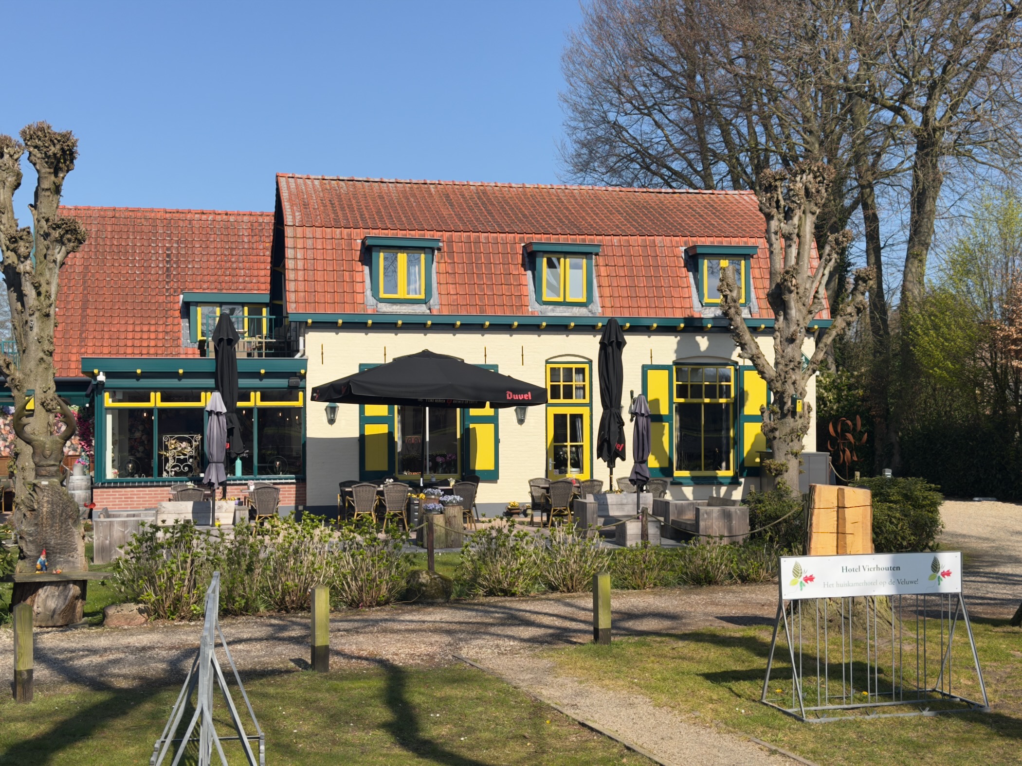 Yellow and green restaurant with red-tiled roof and outdoor terrace seating