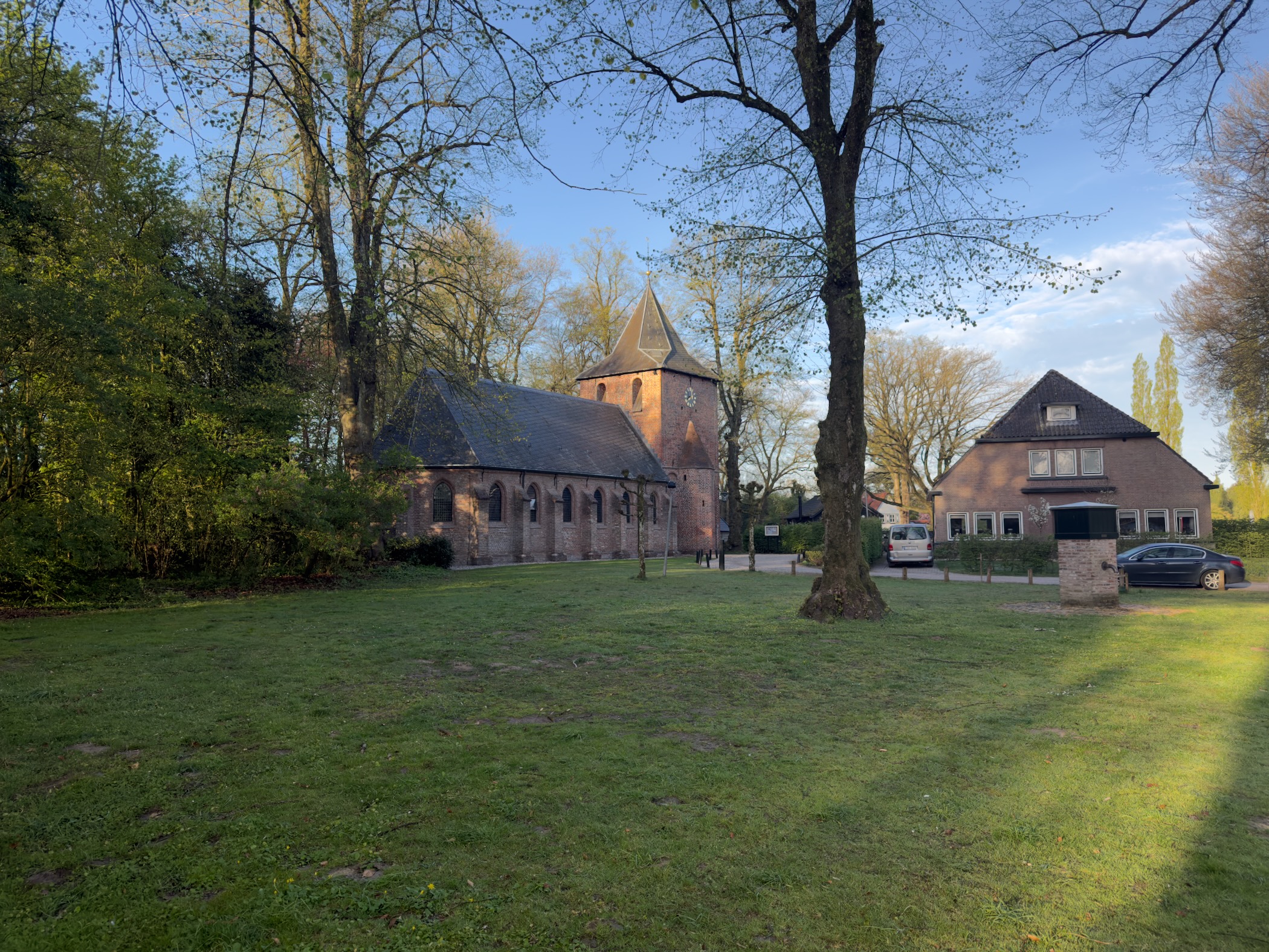 Church and house in the village of Kootwijk surrounded by trees in early spring light