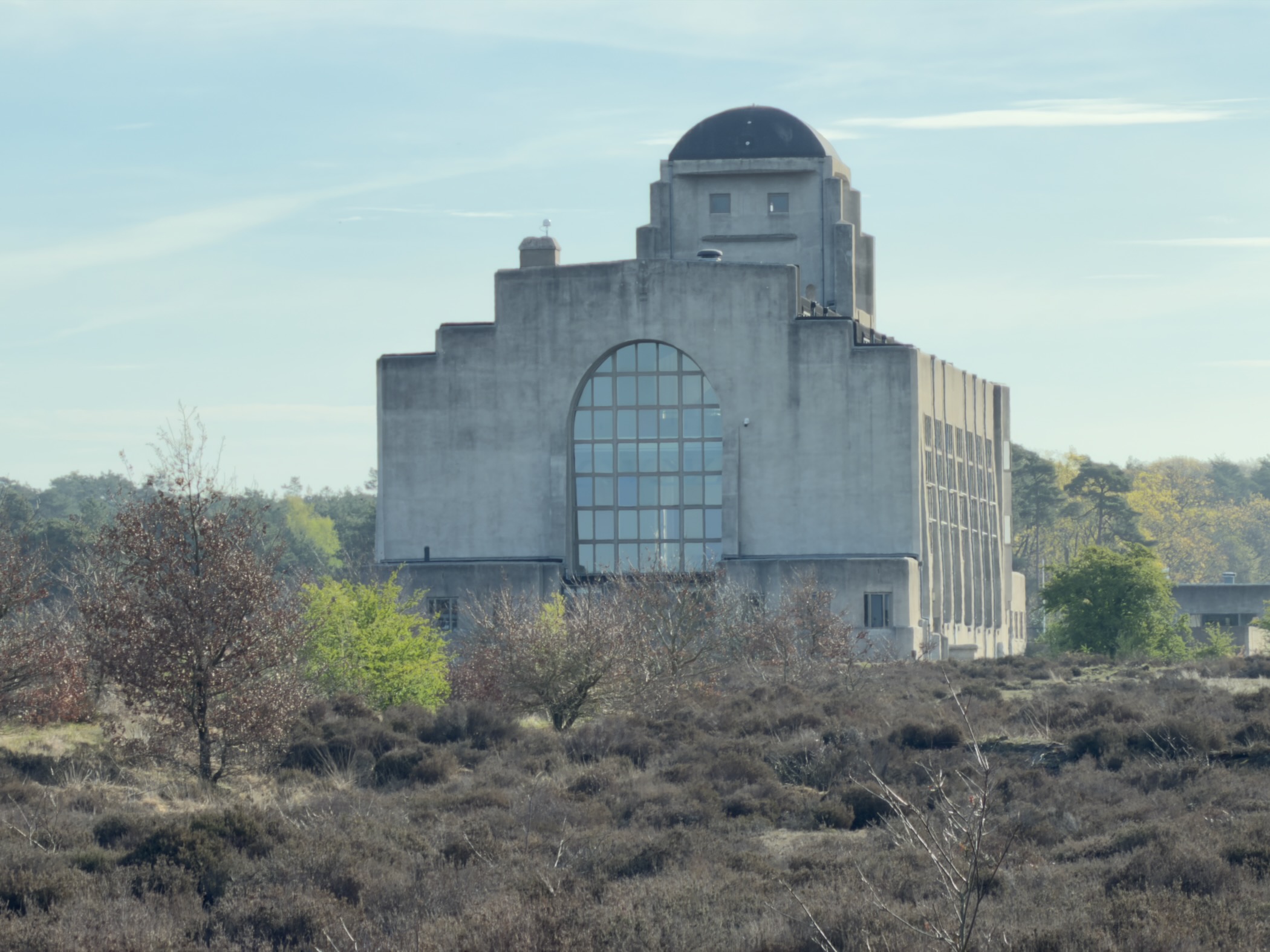 Close-up view of the monumental Radio Kootwijk building rising above the heather