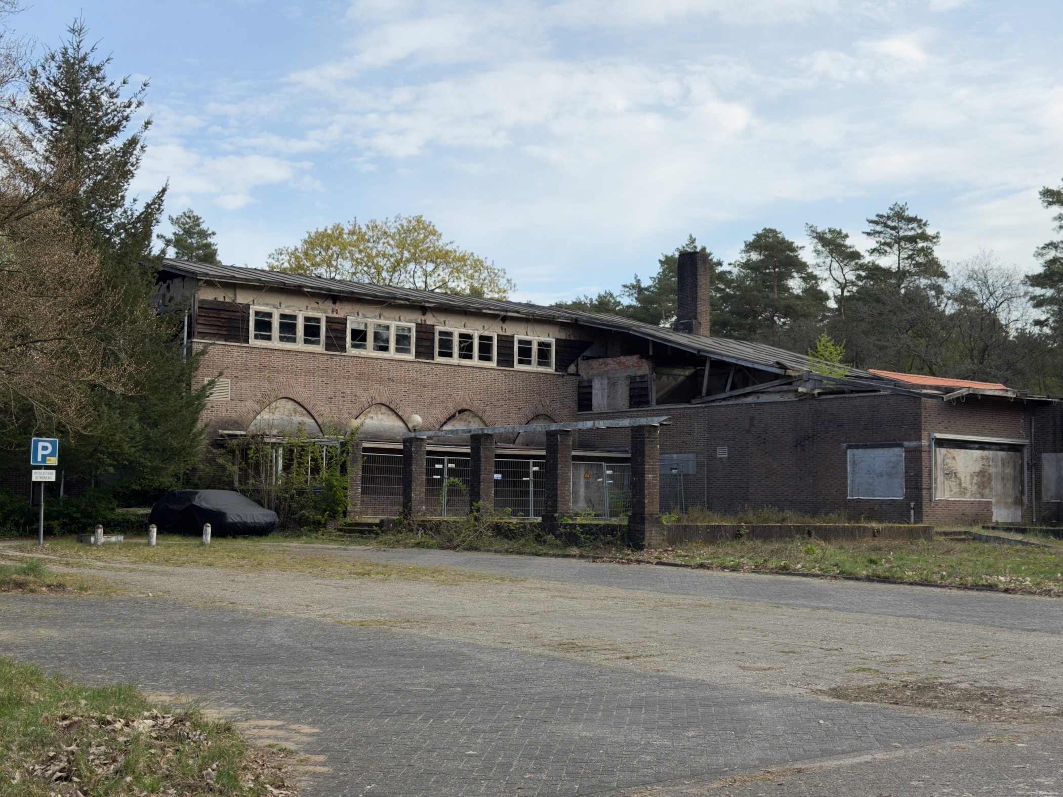Abandoned brick building with a partially collapsed roof at Radio Kootwijk