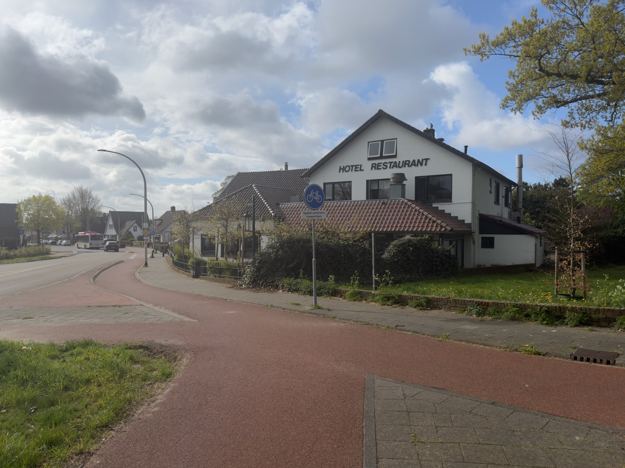 Hotel Restaurant building on a village street corner in Loenen with a red cycling path