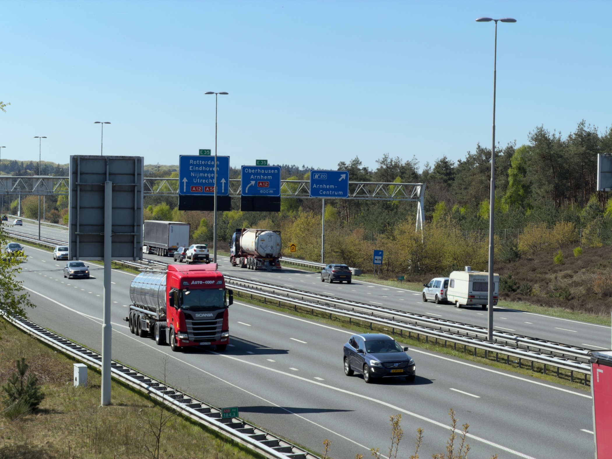Motorway with trucks and cars below direction signs for Arnhem Centrum