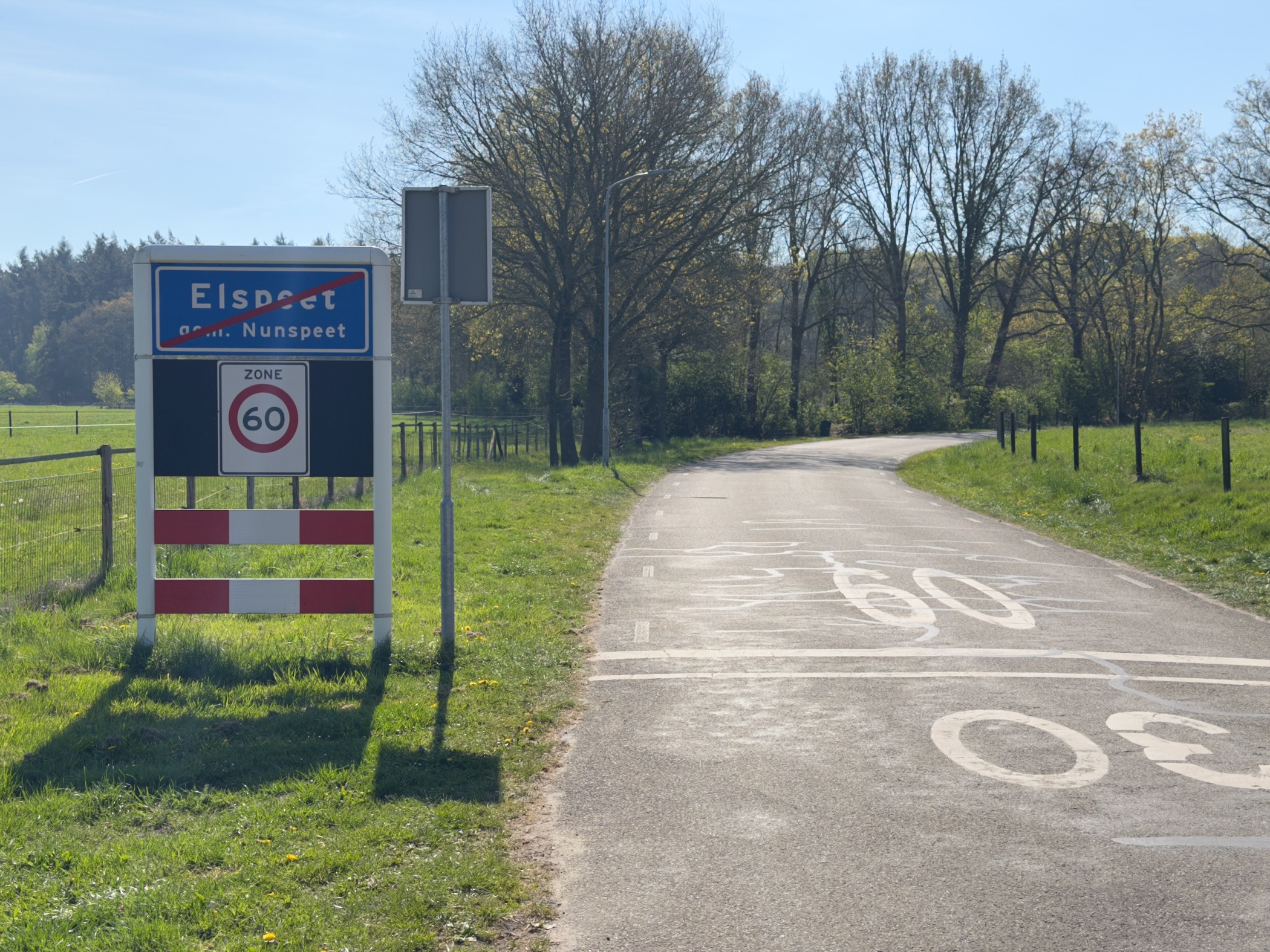 Town boundary sign Elspeet gem. Nunspeet with 60 km/h zone markings on the road