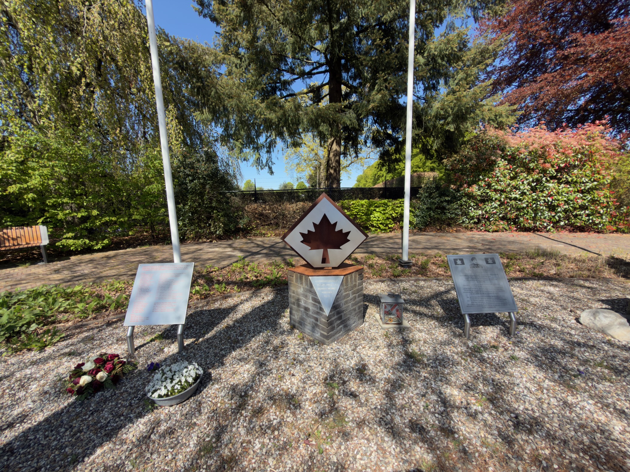 A Canadian war memorial with a maple leaf between two flagpoles