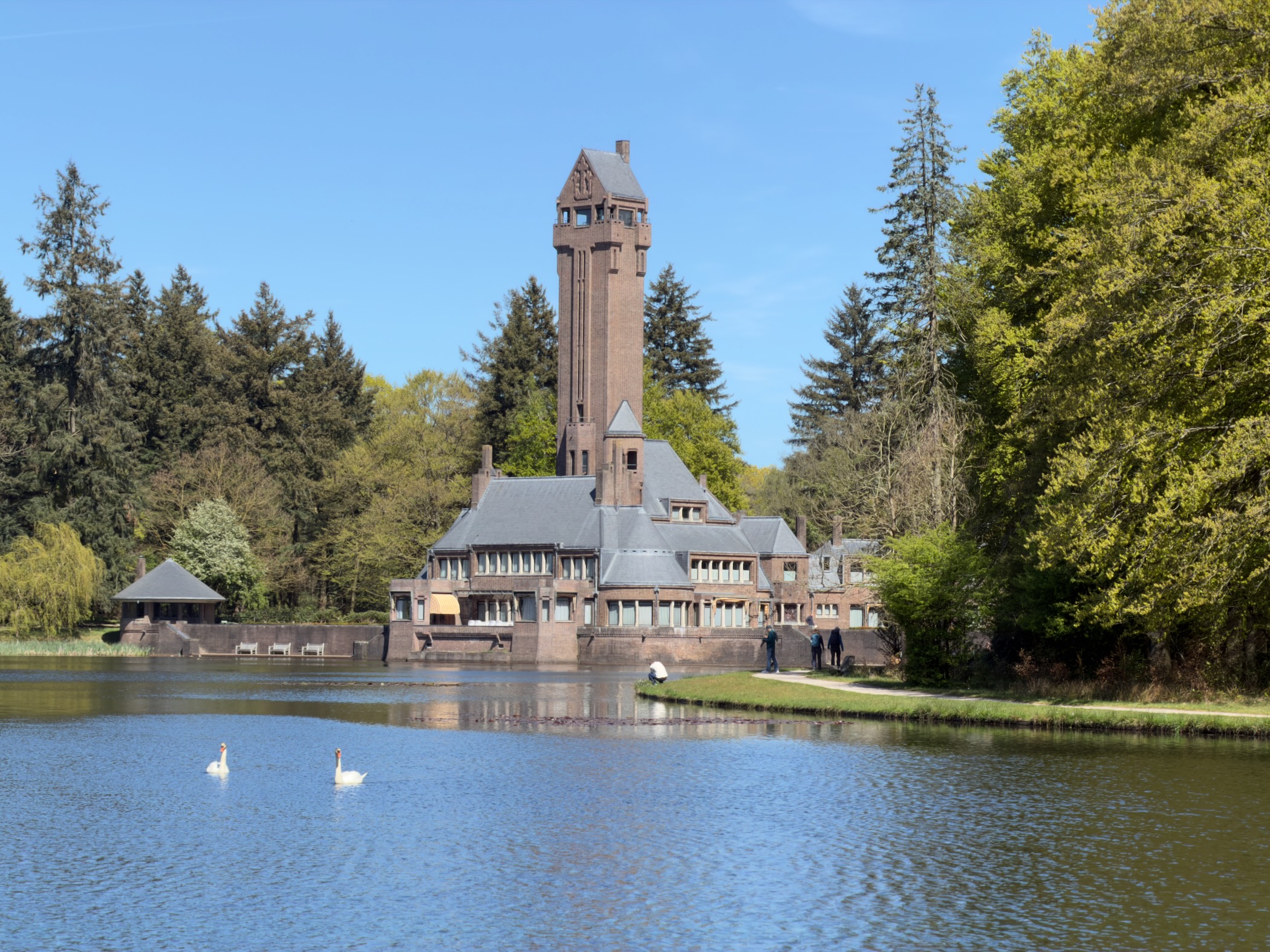 Saint Hubertus hunting lodge with its tall tower and swans on the pond