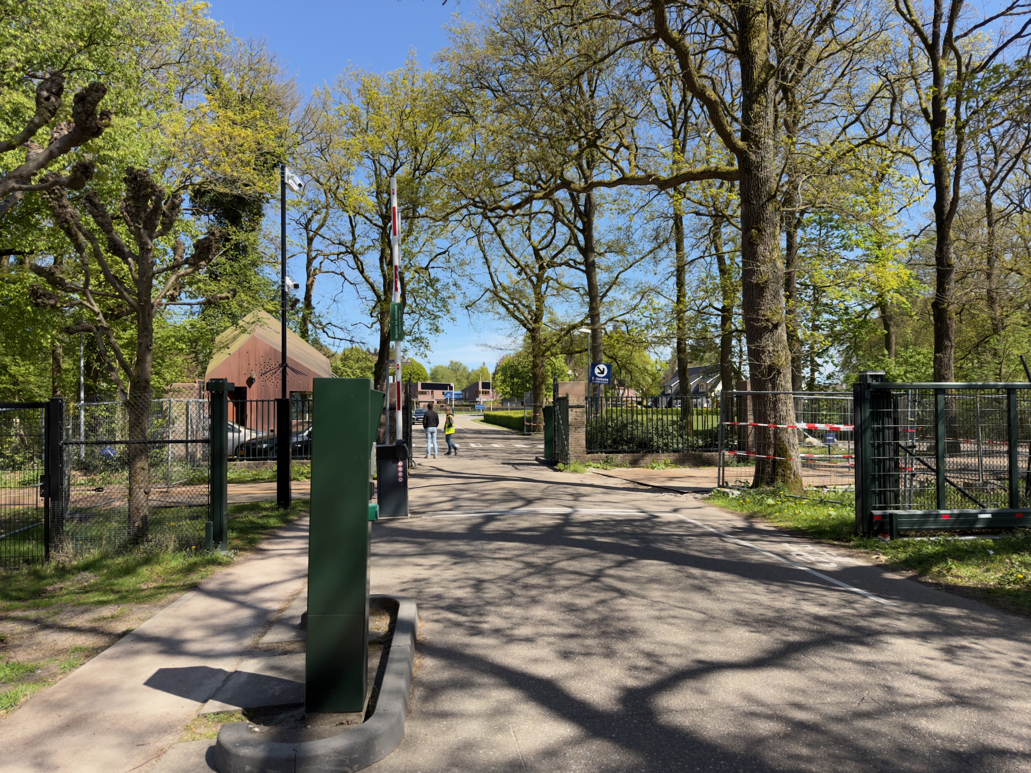Park exit gate with flagpole and fenced grounds beyond