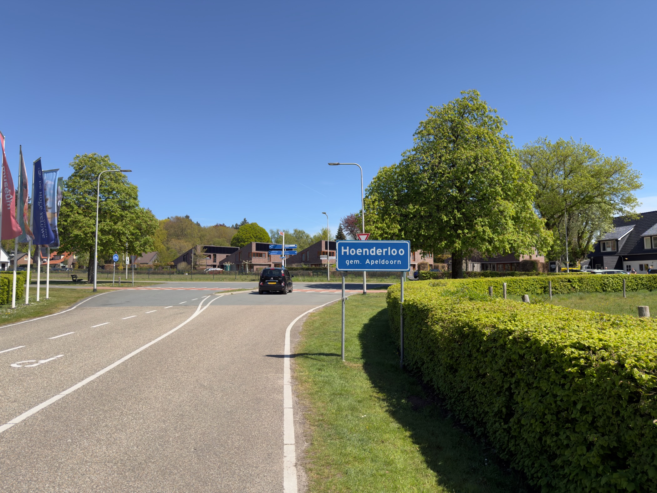 Hoenderloo town sign at the edge of the village under a clear sky