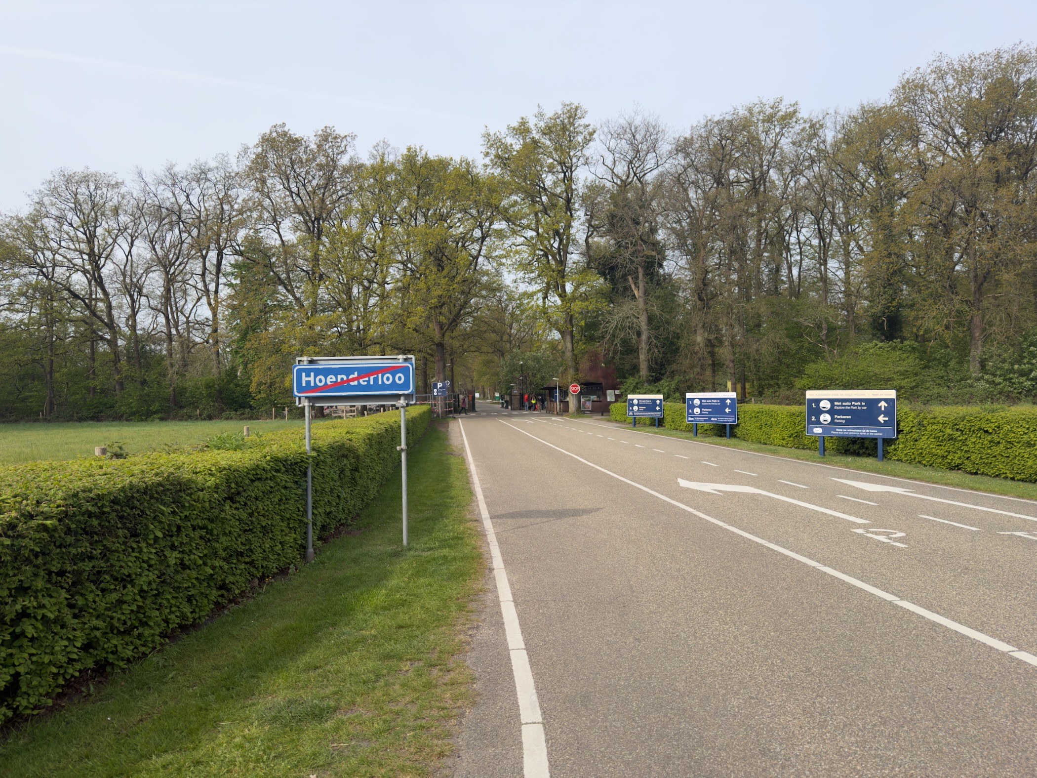 Hoenderloo town entrance sign beside the road with information signposts